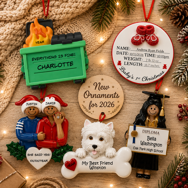 Flat lay featuring new personalized Christmas ornaments for 2026, including a baby's first Christmas, engagement, graduation, pet, and "Everything Is Fine!" dumpster ornament arranged in a cozy holiday setting.
