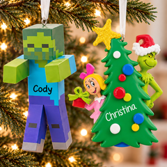 Personalized Hallmark Christmas ornaments featuring a Minecraft zombie with the name Cody and a Grinch Christmas tree ornament with the name Christina, hanging on a festive tree.