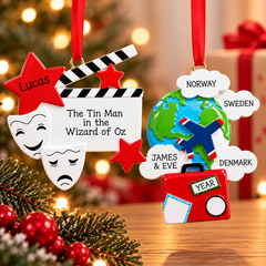 Personalized hobbies and interests Christmas ornaments featuring a theater ornament with a clapperboard and drama masks alongside a travel ornament with a globe, airplane, and suitcase, displayed against a festive holiday background.