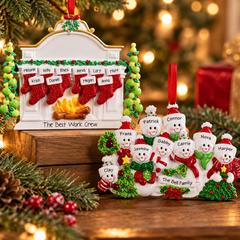Personalized large family Christmas ornaments featuring a custom stocking fireplace ornament and a snowman family ornament, displayed with festive greenery and warm Christmas lights.