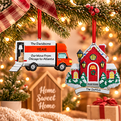 Personalized new home Christmas ornaments featuring a moving truck and red first home ornament hanging from festive evergreen branches with warm holiday lights.