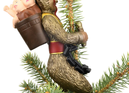 Krampus Christmas tree topper featuring a horned folklore figure with a long red tongue, black chain, branches, and child on his back.