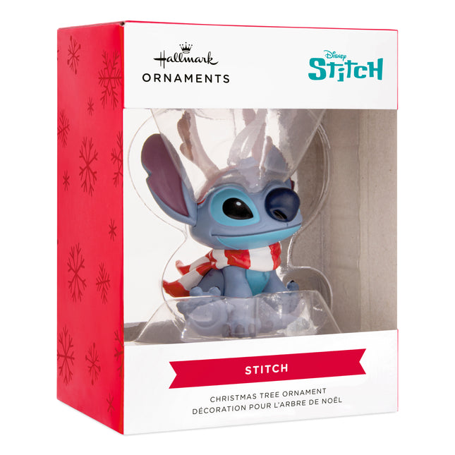 Disney Stitch Christmas ornament wearing brown reindeer antlers and a red and white striped scarf, featuring blue Stitch with large ears and a white hanging ribbon.