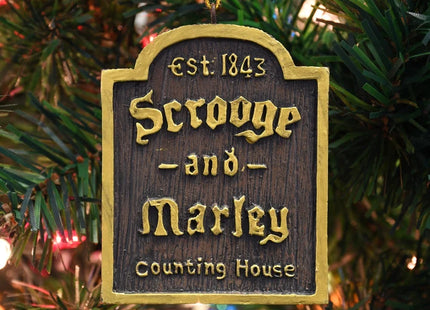 Scrooge and Marley Counting House Christmas ornament with dark wood-look finish, gold lettering, and Est. 1843 detail.