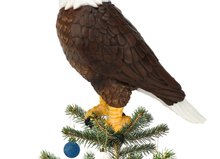 Bald eagle Christmas tree topper featuring a detailed brown body, white head and tail, yellow beak, and talons perched atop a Christmas tree.