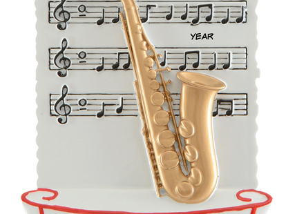 Personalized saxophone Christmas ornament with name and year featuring a gold saxophone and sheet music background.
