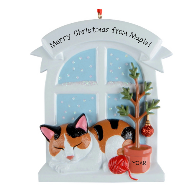 Personalized calico cat Christmas ornament by a snowy window with custom name and year.
