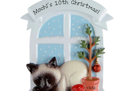 Personalized Siamese cat Christmas milestone ornament by a snowy window with custom name, Christmas number and year.