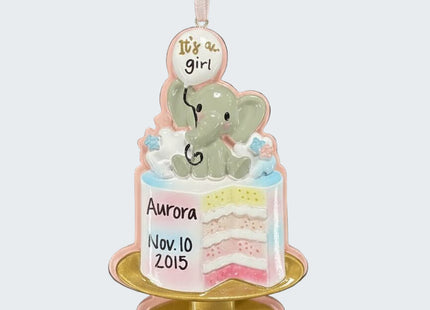 Decorative baby shower ornament with a cake and elephant, personalized with 'It's a girl' and 'Aurora'.