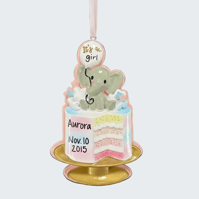 Decorative baby shower ornament with a cake and elephant, personalized with 'It's a girl' and 'Aurora'.