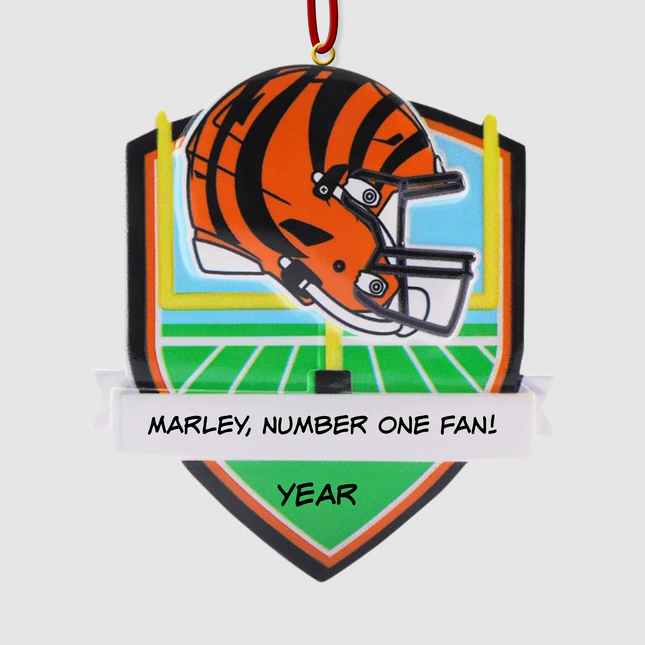 Personalized Cincinnati Bengals football helmet Christmas ornament with custom name and year on a football field background.