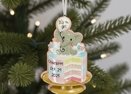 Decorative ornament with an elephant and cake design, hanging on a Christmas tree.