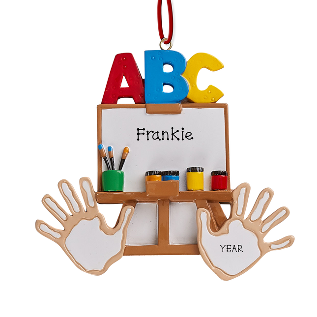 Personalized preschool art easel Christmas ornament with custom name and year featuring ABC letters, paintbrushes, paint, and handprints.