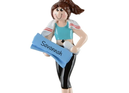 Personalized female fitness Christmas ornament featuring a brunette woman in workout clothes holding a blue exercise mat with custom name and year.