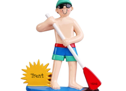 Personalized stand up paddleboarding Christmas ornament featuring a paddleboarder with sunglasses, a yellow sun personalized with Trent, and a red paddle blade for the year.