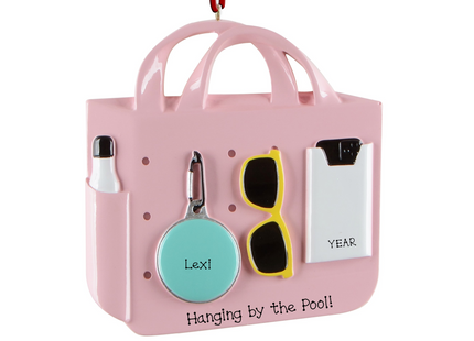 Personalized beach and pool tote bag Christmas ornament with custom name, custom message, and year featuring sunglasses, sunscreen, a float, and summer accessories.