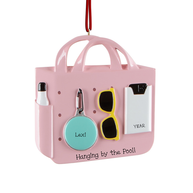 Personalized beach and pool tote bag Christmas ornament with custom name, custom message, and year featuring sunglasses, sunscreen, a float, and summer accessories.