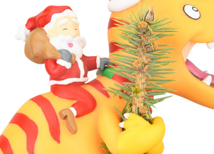 Santa riding a yellow dinosaur Christmas tree topper featuring a toothy dinosaur wearing a red Santa hat.