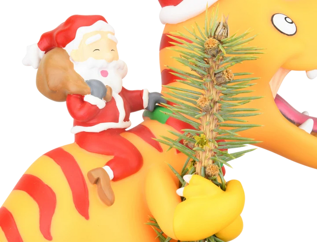 Santa riding a yellow dinosaur Christmas tree topper featuring a toothy dinosaur wearing a red Santa hat.