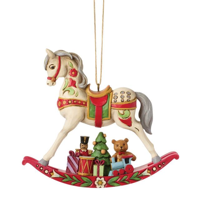 Traditional rocking horse Christmas ornament featuring a teddy bear, toy train, nutcracker, Christmas tree, and wrapped presents.